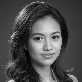 Black and white portrait of a woman with wavy hair looking thoughtfully at the camera.